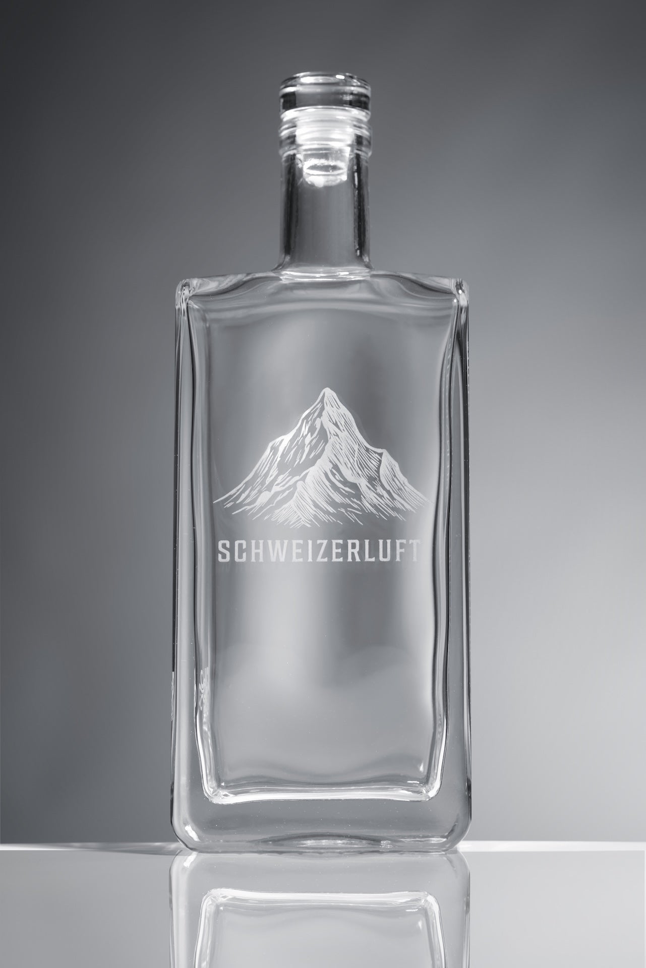 Detail view of clear, food-safe glass bottle showing thickness, edges, and craftsmanship.