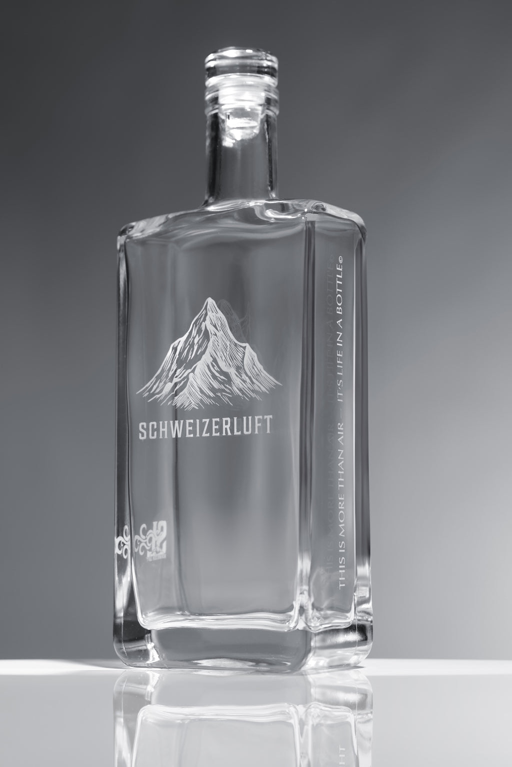 SchweizerLuft® Summit Edition 500 ml clear glass bottle with engraved Swiss mountain design.