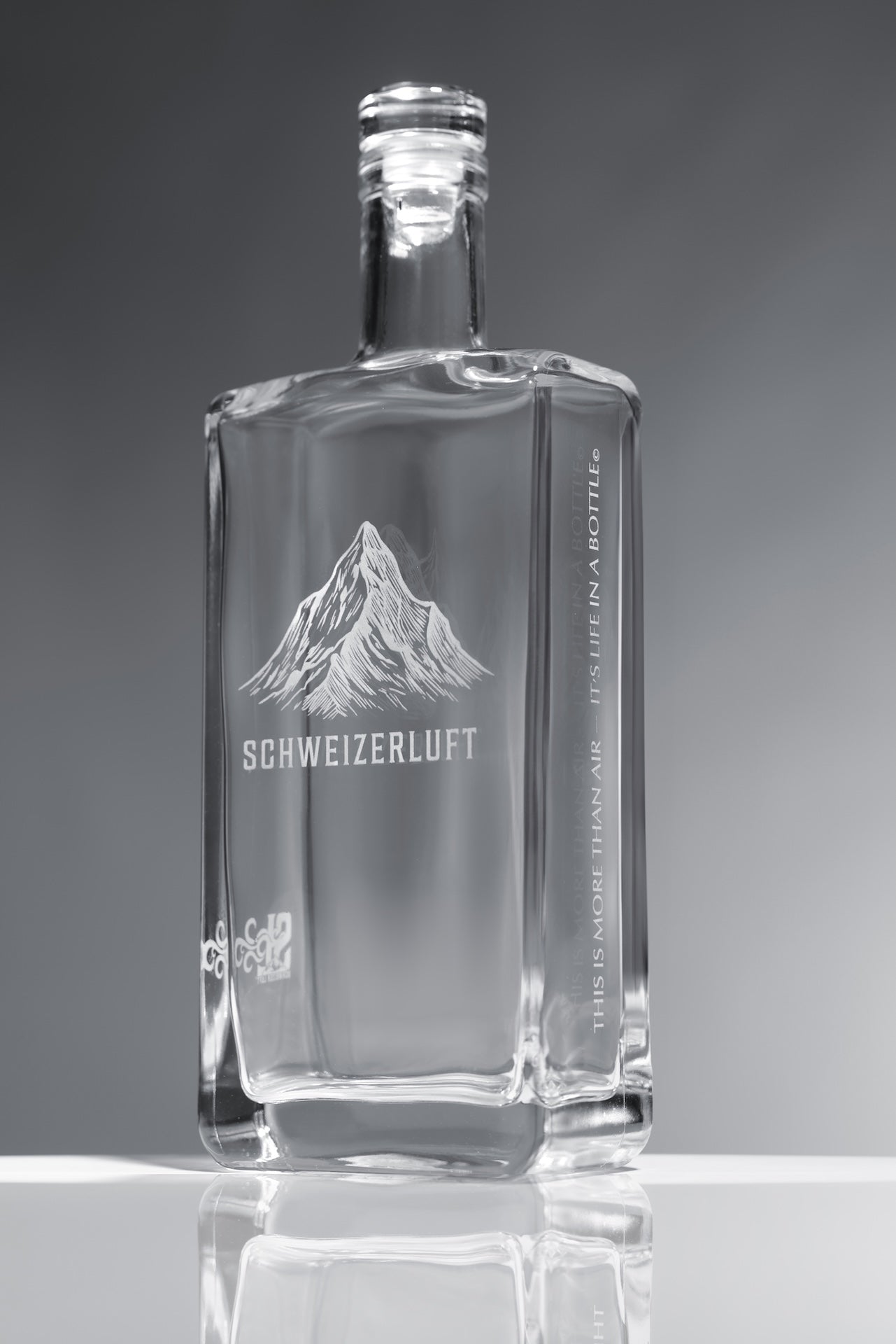 SchweizerLuft® Summit Edition 500 ml clear glass bottle with engraved Swiss mountain design.